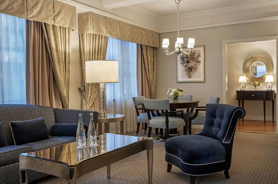 Elegantly decorated suite with dining set, couch, and modern furniture at Warwick New York.