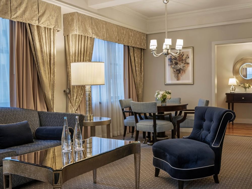Elegant Accessible On the Avenue Suite living area with plush seating and dining table at Warwick New York