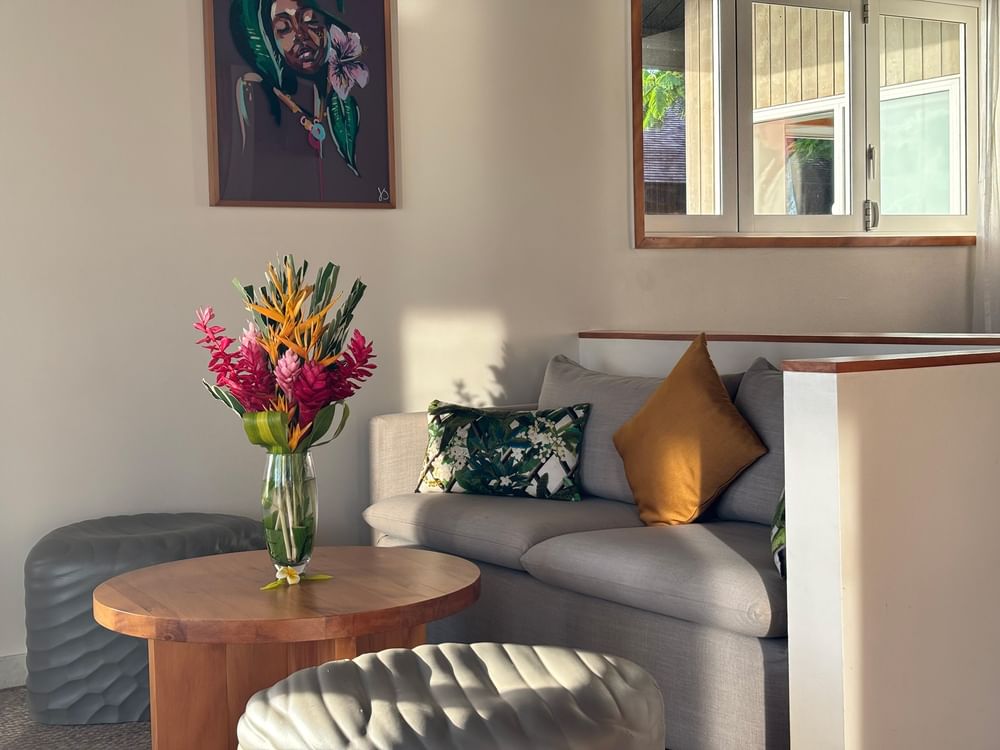 Overwater Villa living area with sofa, artwork, and flowers at Warwick Le Lagon - Vanuatu in Efate.