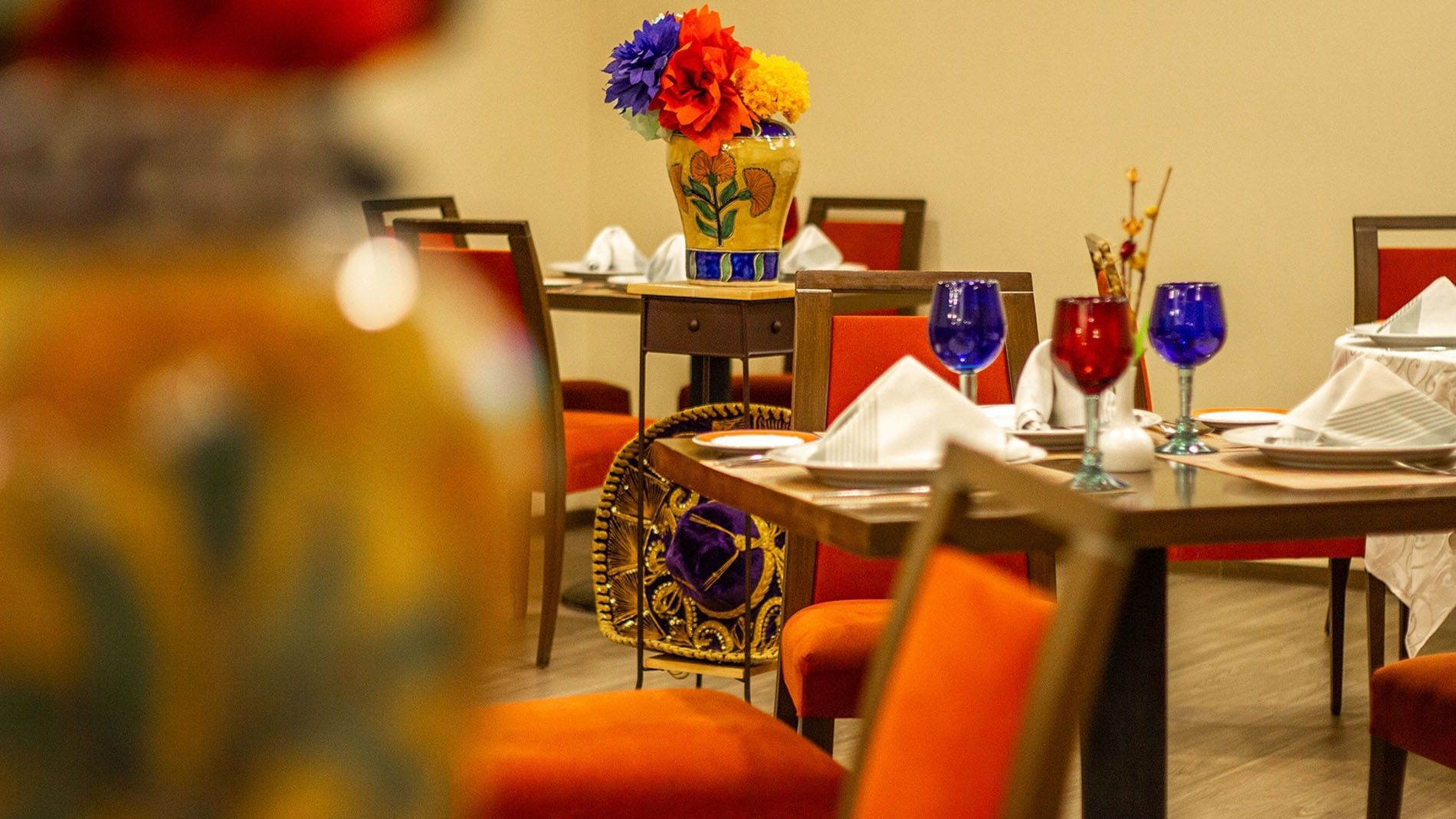 Elegant dining area with colorful decorations at Cualli in Camino Real Aeropuerto Mexico, Ciudad de Mexico.