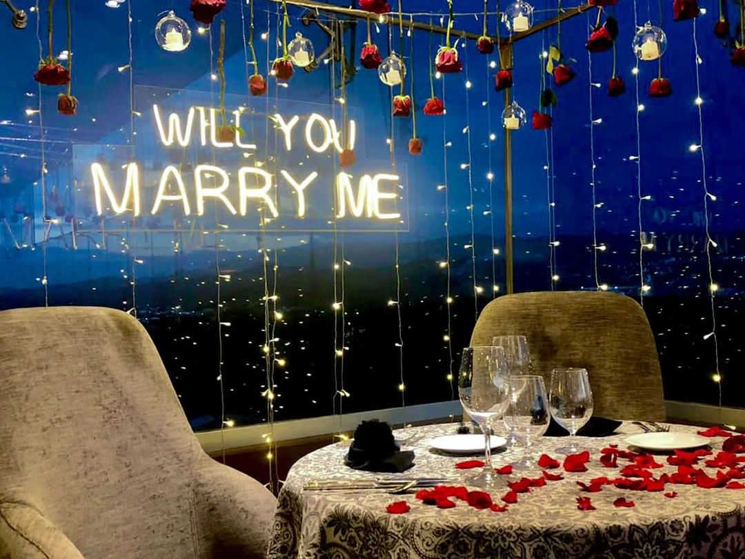 Romantic proposal setting at Tangamanga Terrace, Fiesta Americana San Luis Potosí, adorned with red roses, twinkling lights