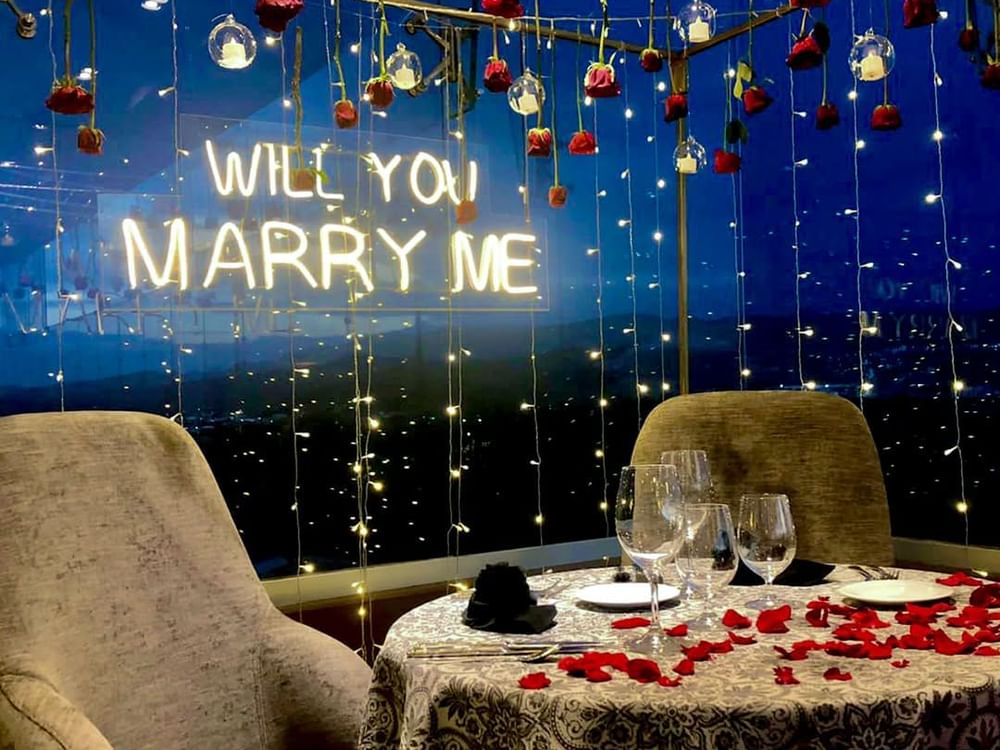 Romantic proposal setting at Tangamanga Terrace, Fiesta Americana San Luis Potosí, adorned with red roses, twinkling lights