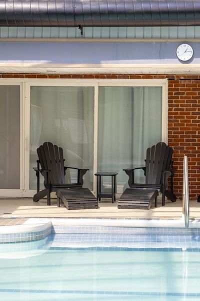Two chairs with footrests wait by the pool, making it one of the best Charlottetown hotels with pools at Rodd Royalty