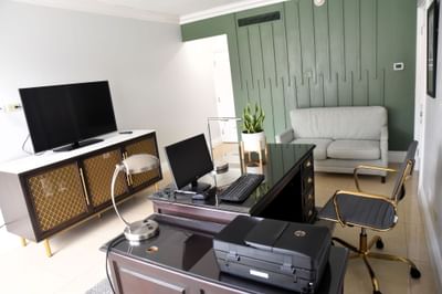 Work desk with chair, TV & a cozy couch in Executive Office Suite at Courtleigh Hotel & Suites