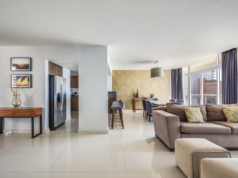 Spacious living room featuring a large gray sofa, a kitchenette, and city views in Penthouse Luxury at Sunvivia Mazatlán