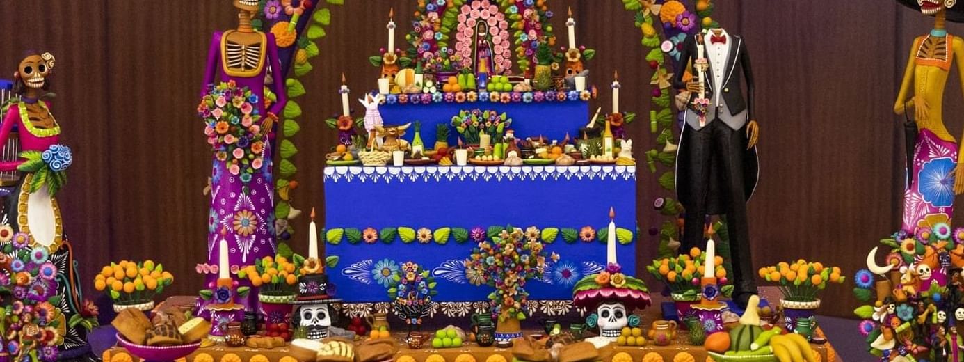 Elaborate Day of the Dead altar with colorful decorations and skeletons, at Marquis Los Cabos Resort