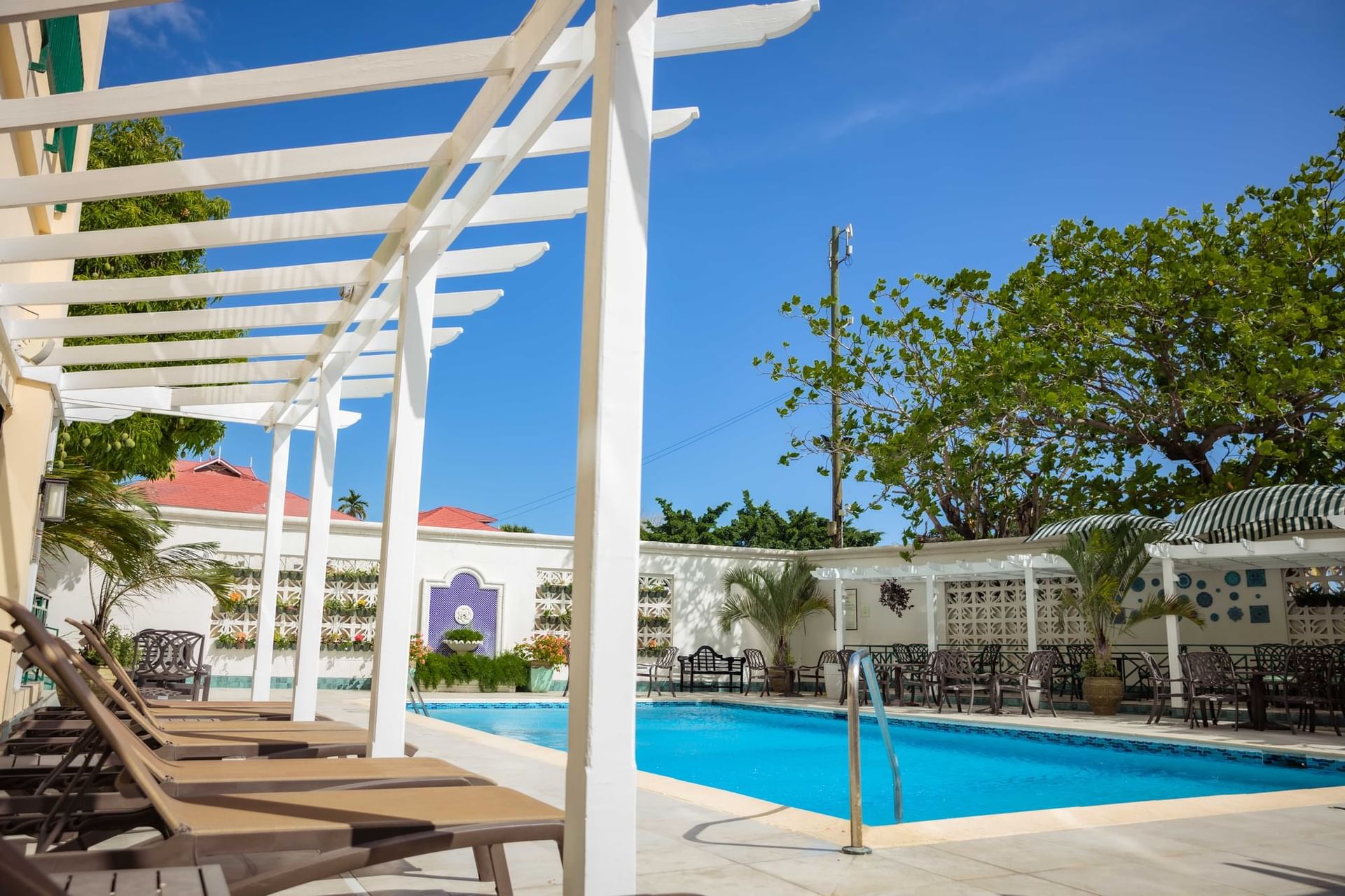 A pool with lounge chairs and umbrellas at Courtleigh Hotel & Suites