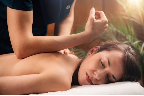 Mujer recibiendo un masaje de tejido profundo en Orquidea Spa & Wellness en Los Altos Resort