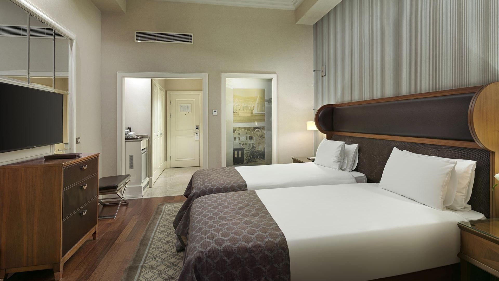 Twin beds with a TV and the kitchenette in Superior Room at Titanic Business Kartal