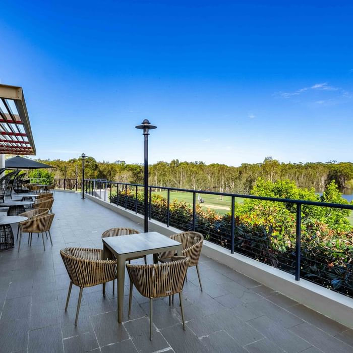 Karinyas Terrace with wicker furniture and a fruit platter overlooking greenery at Mercure Kooindah Waters