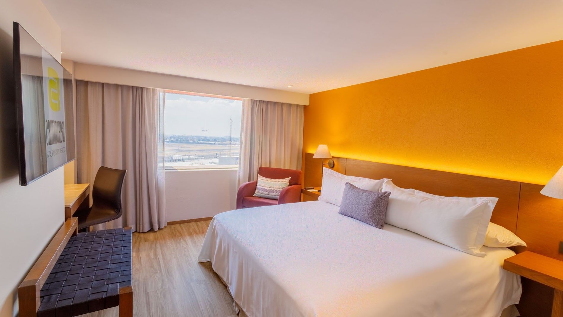 King Deluxe Superior room featuring a large bed with a couch by the window at Camino Real Aeropuerto Mexico