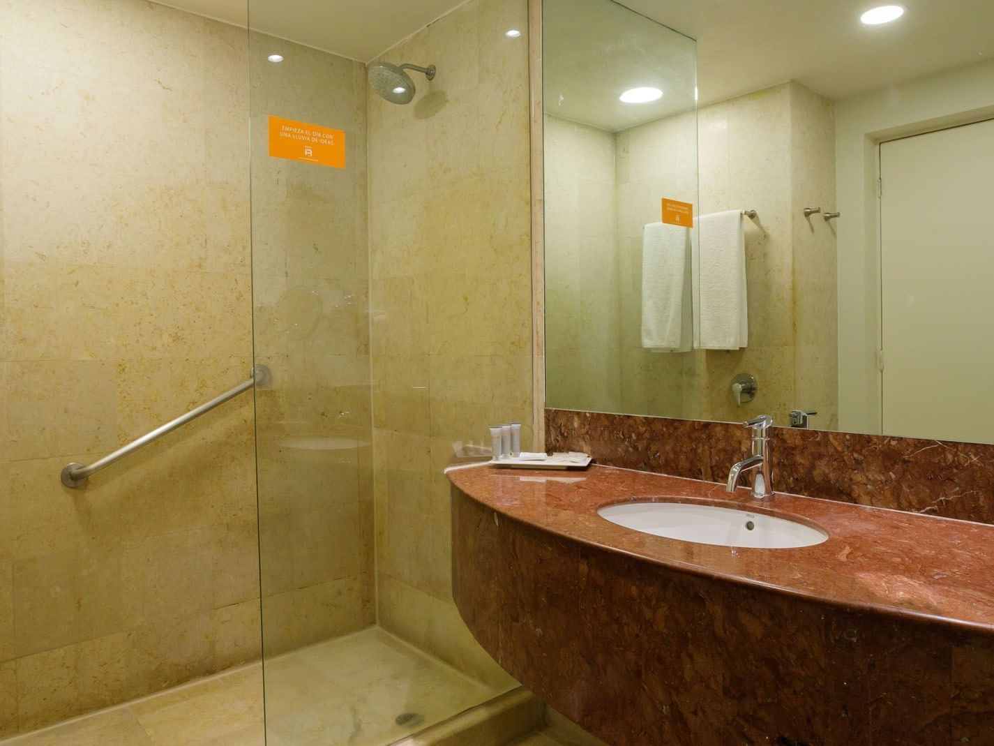 King Deluxe bathroom with a marble vanity, glass shower door, and modern chrome fixtures at Real Inn Torreon