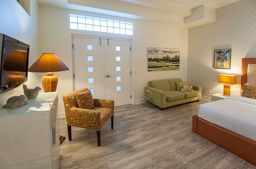 a chair, couch, and bed in a hotel room