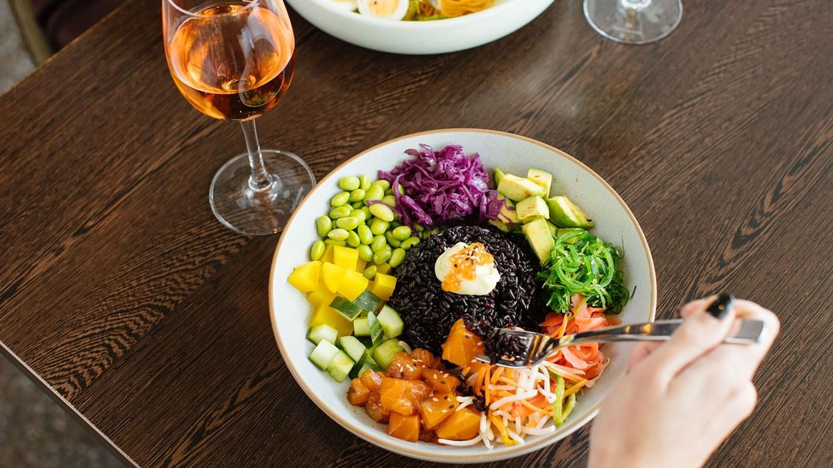 Close-up of various veggies and black rice & glass of wine in the restaurant at Crown Hotels
