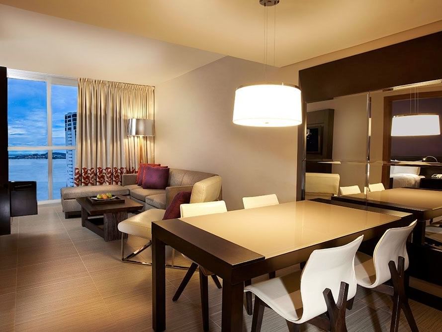 Mesa de comedor con sala de estar en Suite Premium Vista al Mar en Megapolis Hotel Panamá