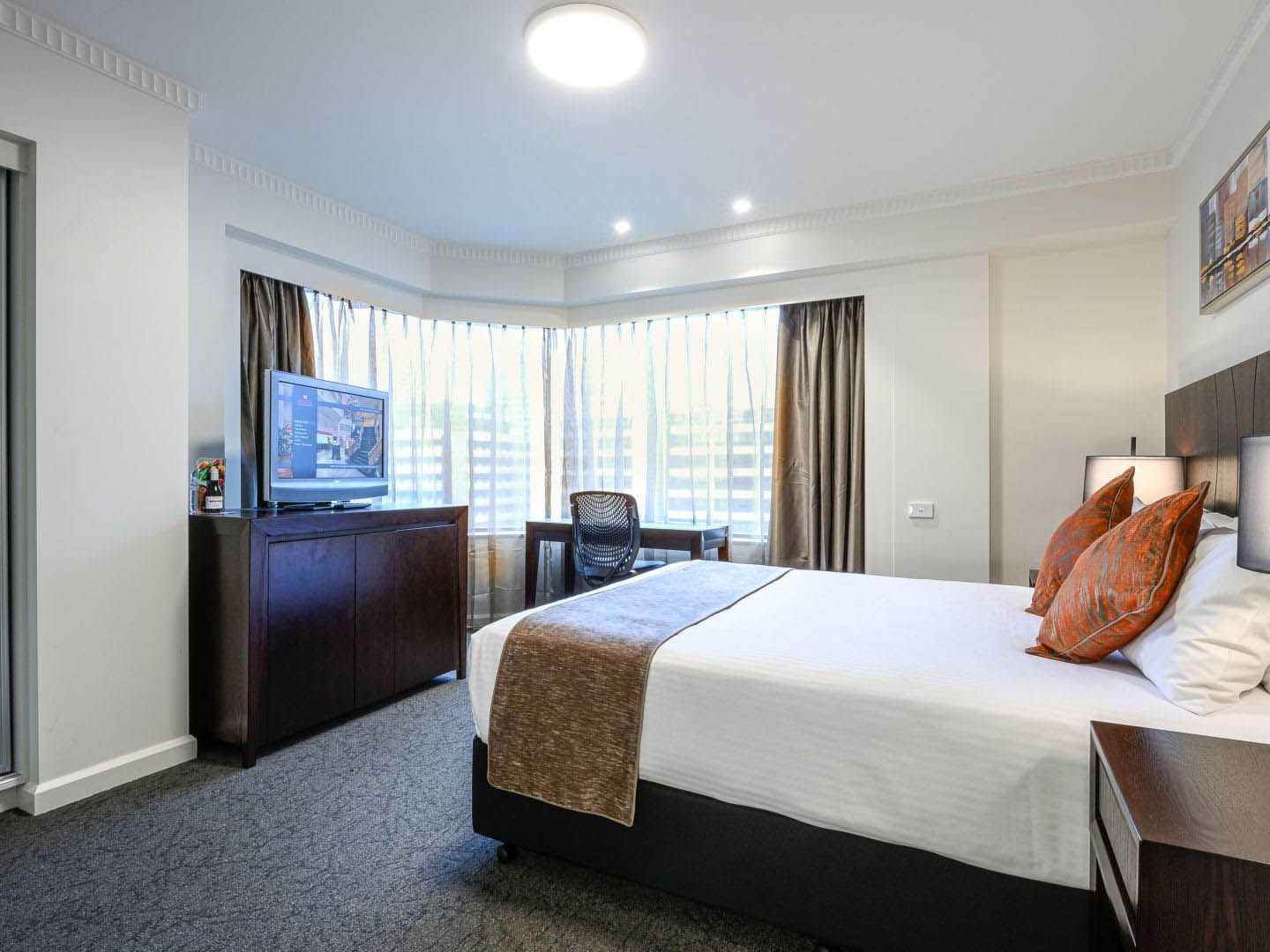 TV stand by the king bed in Executive Queen Room at Grand Chancellor Adelaide