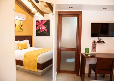 Working desk and a queen bed in the Master Room at Cha Cha Hotel