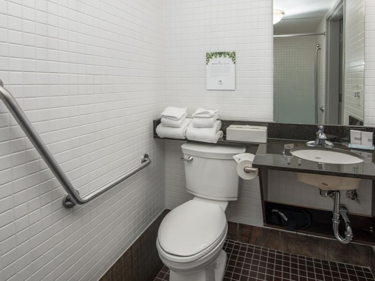 Accessible bathroom with toilet, sink, and towels.