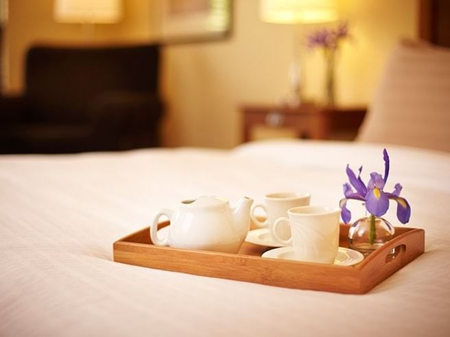 A tea set on a wooden tray on a bed in Deluxe Spa Suite with Balcony at Temple Gardens Hotel & Spa