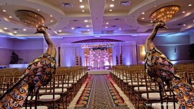 banquet hall with rows of chairs and two peacock statues