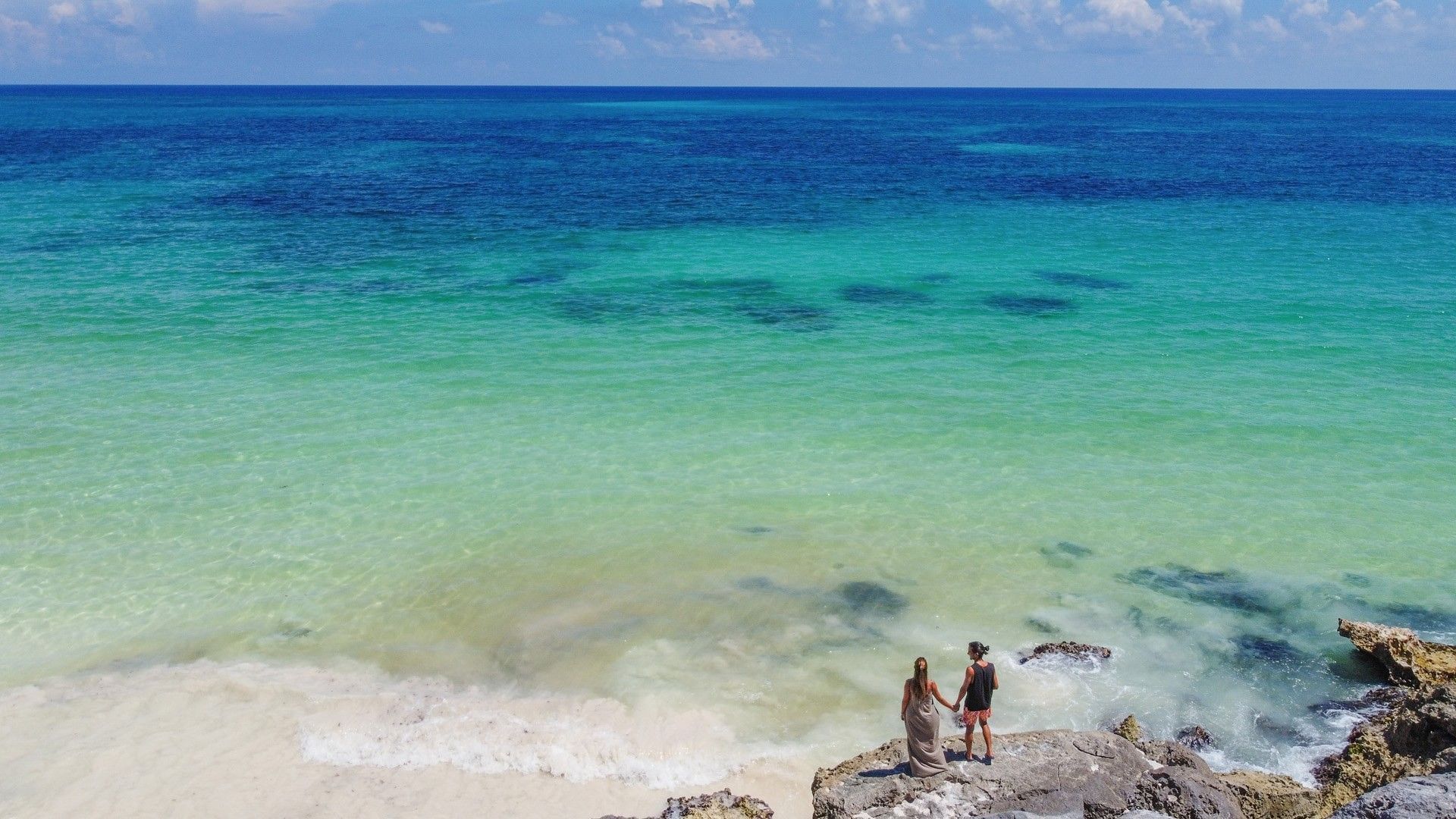 Couple standing together above the turquoise Caribbean near Mi Amor