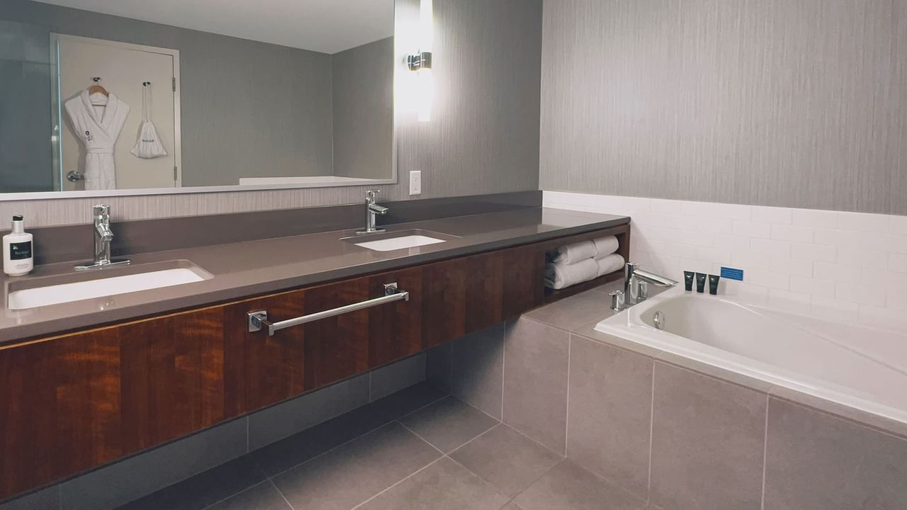 Modern bathroom with large mirror, sink, and bathtub