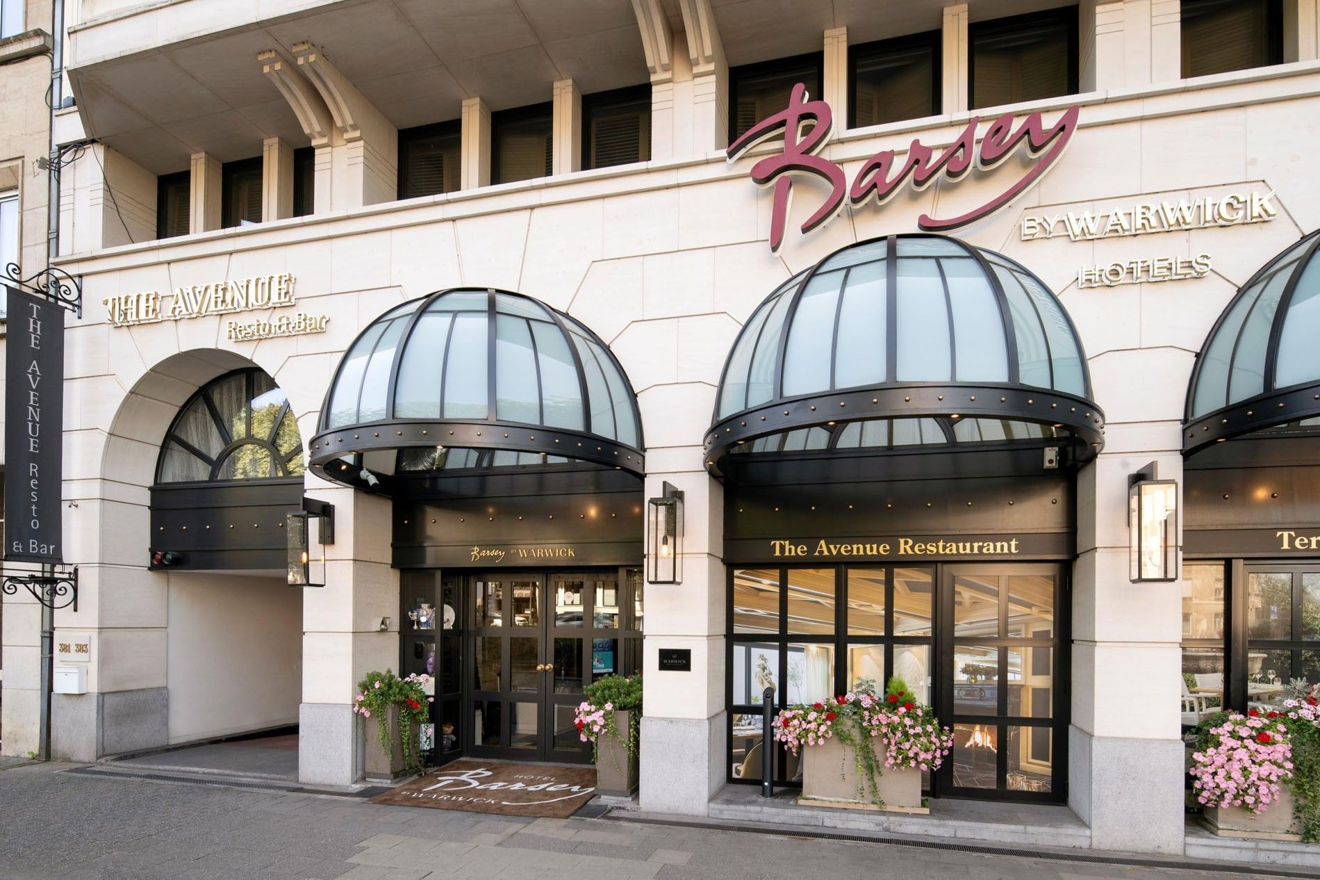 Grand stone facade with black glass awnings and 