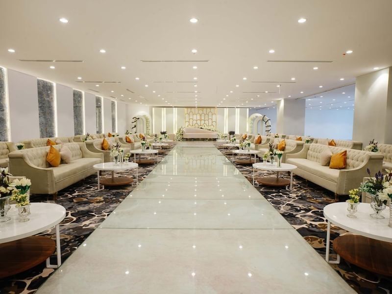 Cream sofas with orange pillows surrounding a polished in Crystal Ball room at Cantonal Hotel by Warwick Riyadh