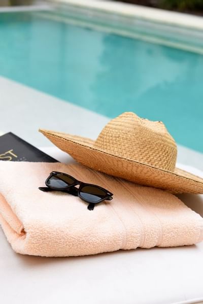 Sombrero, toalla y gafas de sol en una hamaca en Argenta Suites