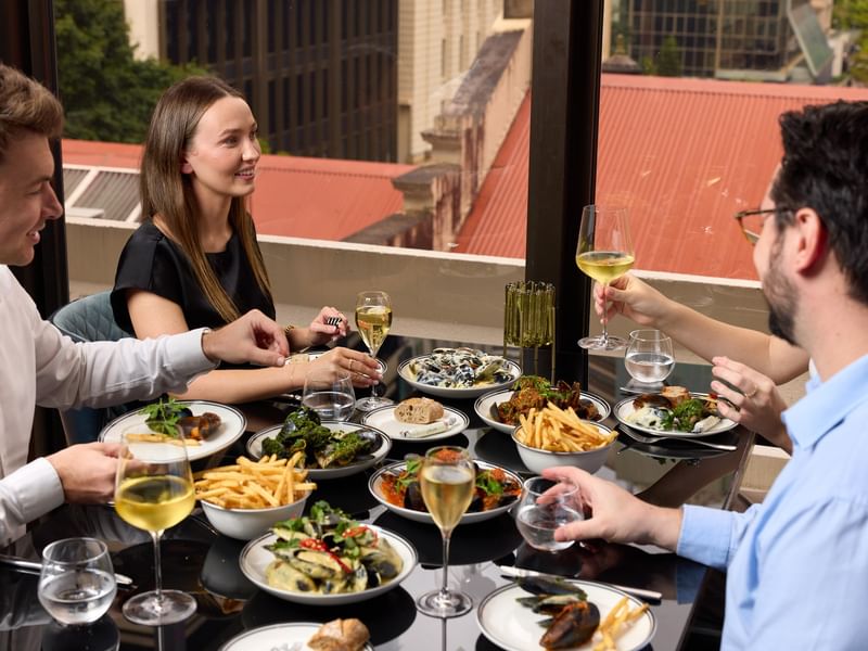 Group of people enjoying a meal with unlimited mussels and fries.