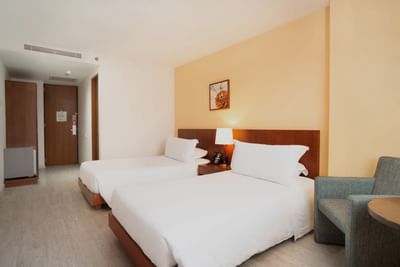 Standard Twin with two single beds, side table, and cozy armchair at Habitel Hotel Select, the best place to stay in Bogota