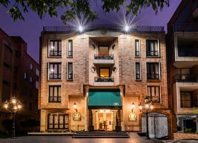 Exterior entrance view of the Le Manoir Bogotá Hotel at night