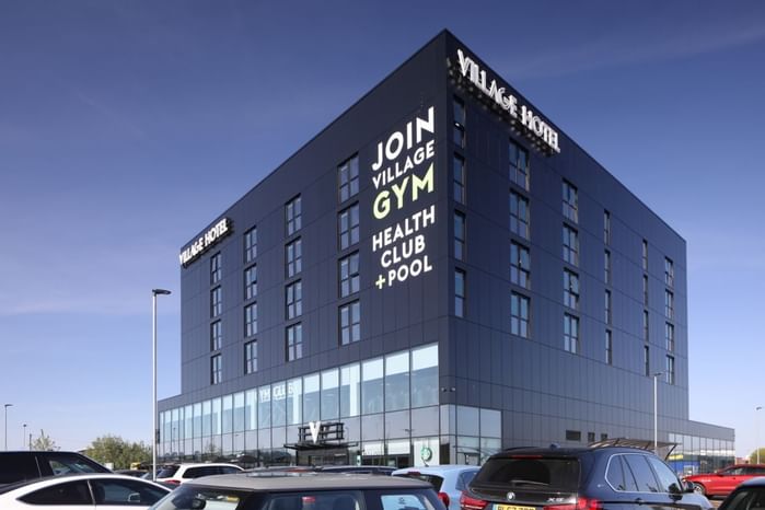 An exterior view of the hotel & car park at Village Hotels