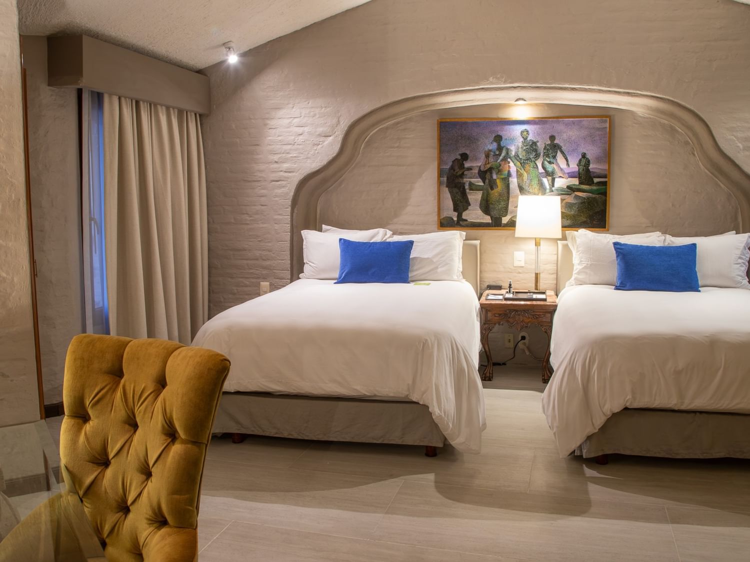 Suite Presidencial King con dos camas king, paredes de piedra y decoración elegante en Quinta Real Guadalajara