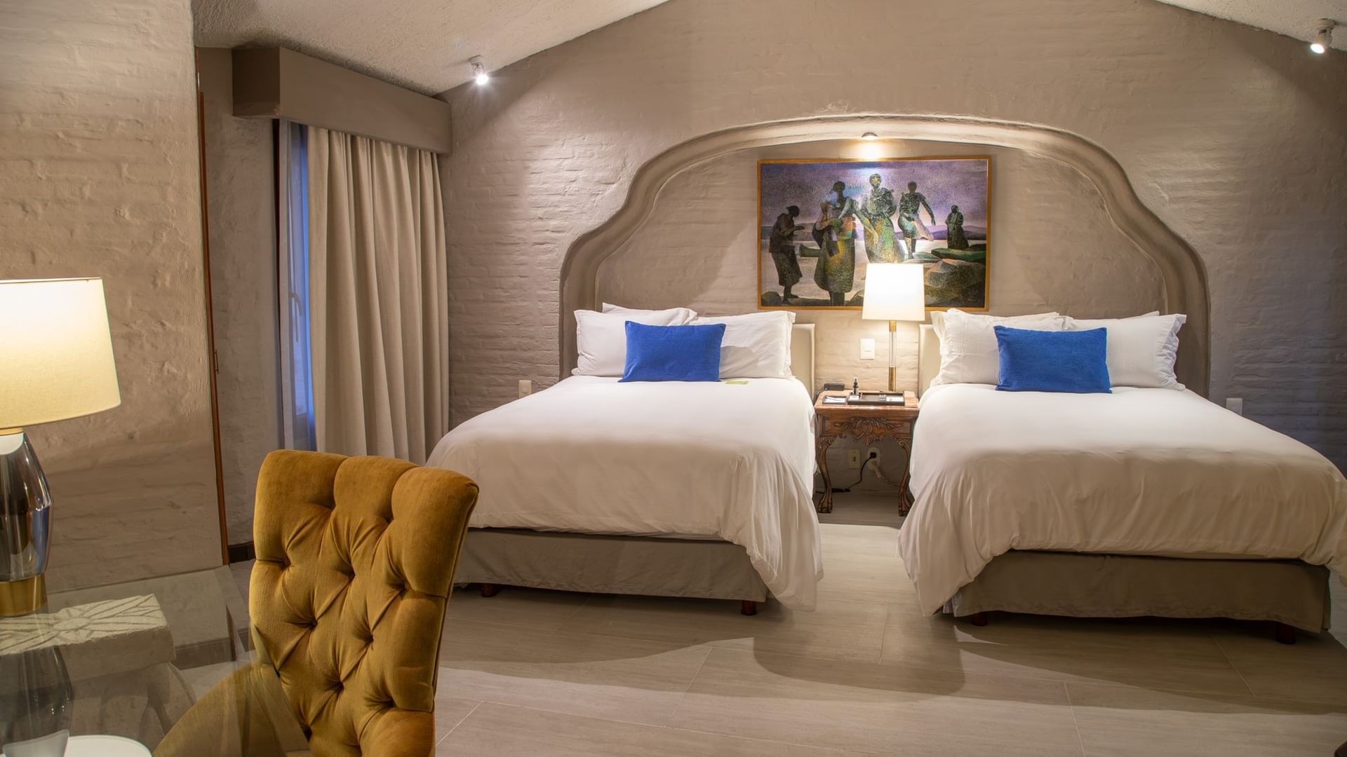 Suite Presidencial King con dos camas king, paredes de piedra y decoración elegante en Quinta Real Guadalajara