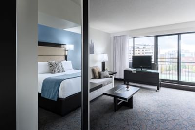 room with bed, sitting area and television on media stand
