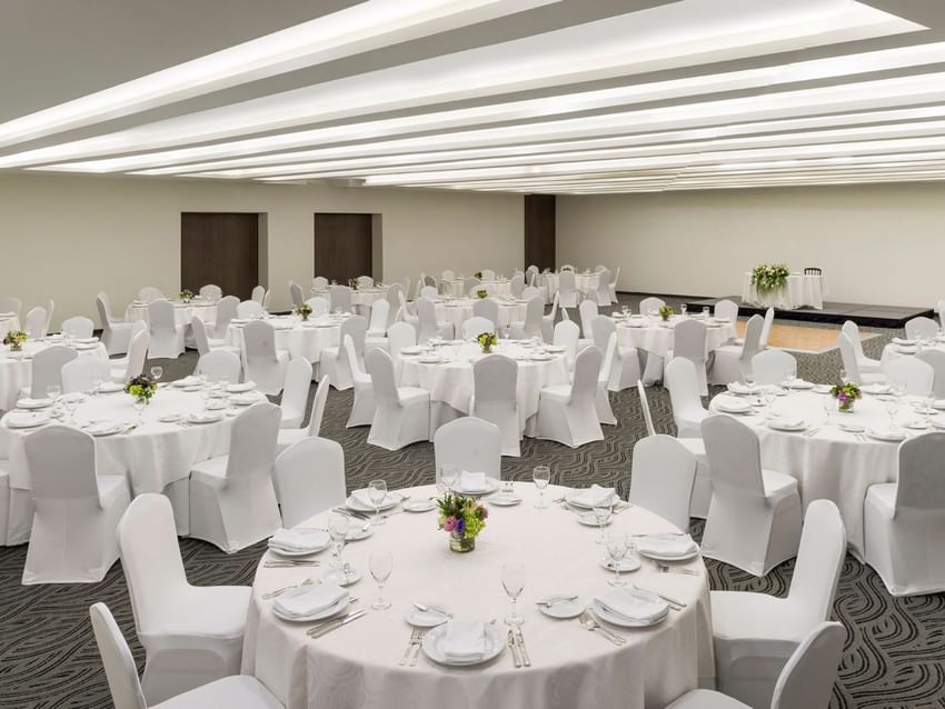 Salón de eventos CDMX en Real Inn Celaya con mesas y sillas decoradas.