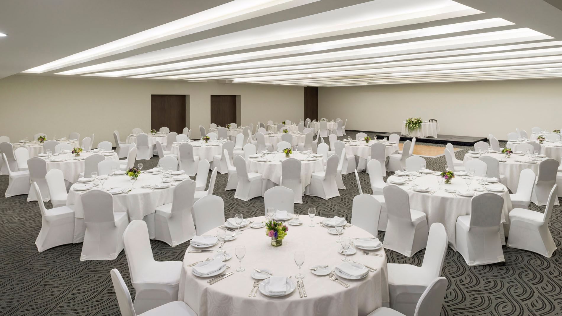 Salón de eventos CDMX en Real Inn Celaya con mesas y sillas decoradas.