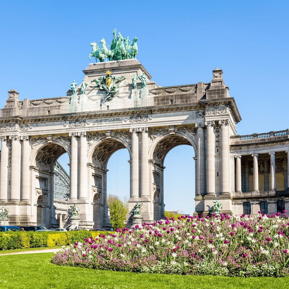 Arcade du Cinquantenaire with flowers set against lush green lawn at Hotel Barsey by Warwick