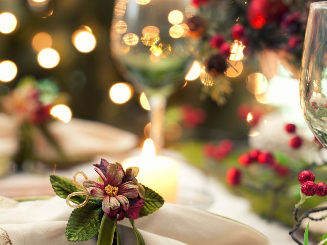 Wine glasses and napkins on a festive table with candles and Christmas decorations at The Sebel Brisbane