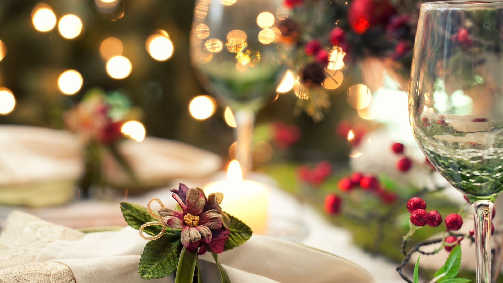 Wine glasses and napkins on a festive table with candles and Christmas decorations at The Sebel Brisbane