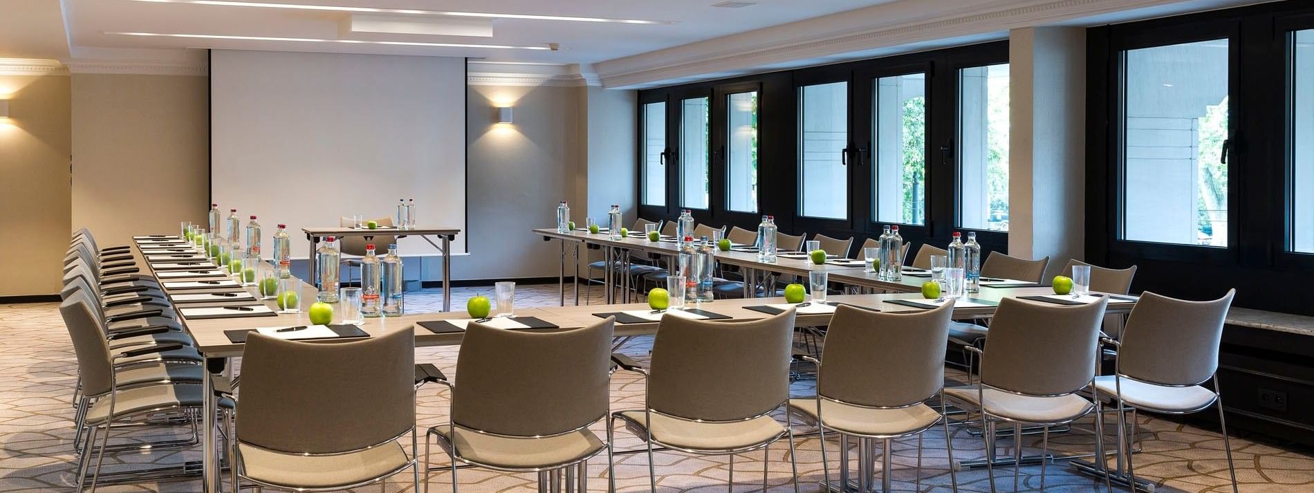 Salle de réunion moderne équipée de tables et de chaises, aménagée pour une conférence à l'hôtel Barsey by Warwick à Bruxelles.