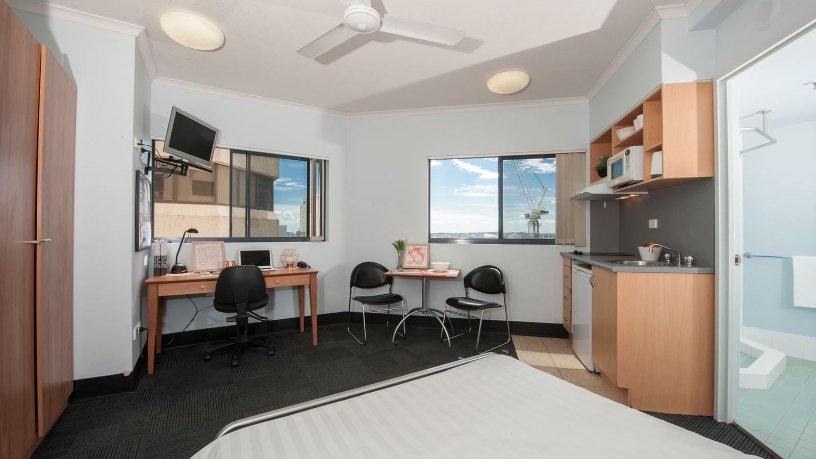 Modern studio room with bed, desk, kitchenette, dining area, and ensuite bathroom at StudentLiving - on Margaret
