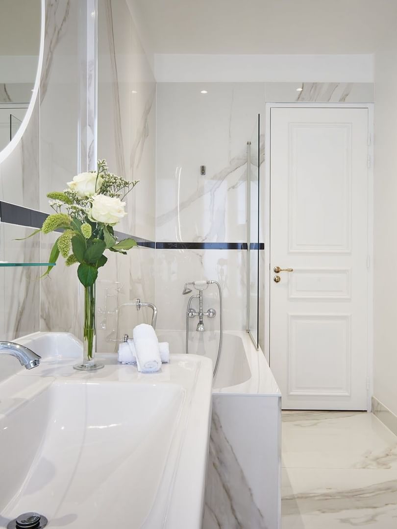 Deluxe Suite Belle Époque bathroom featuring a marble vanity with bathtub at Hotel Westminster Paris