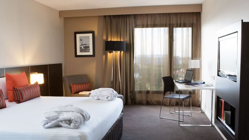 Work desk facing bed and couch by the window in Executive Room at Novotel Sydney International Airport