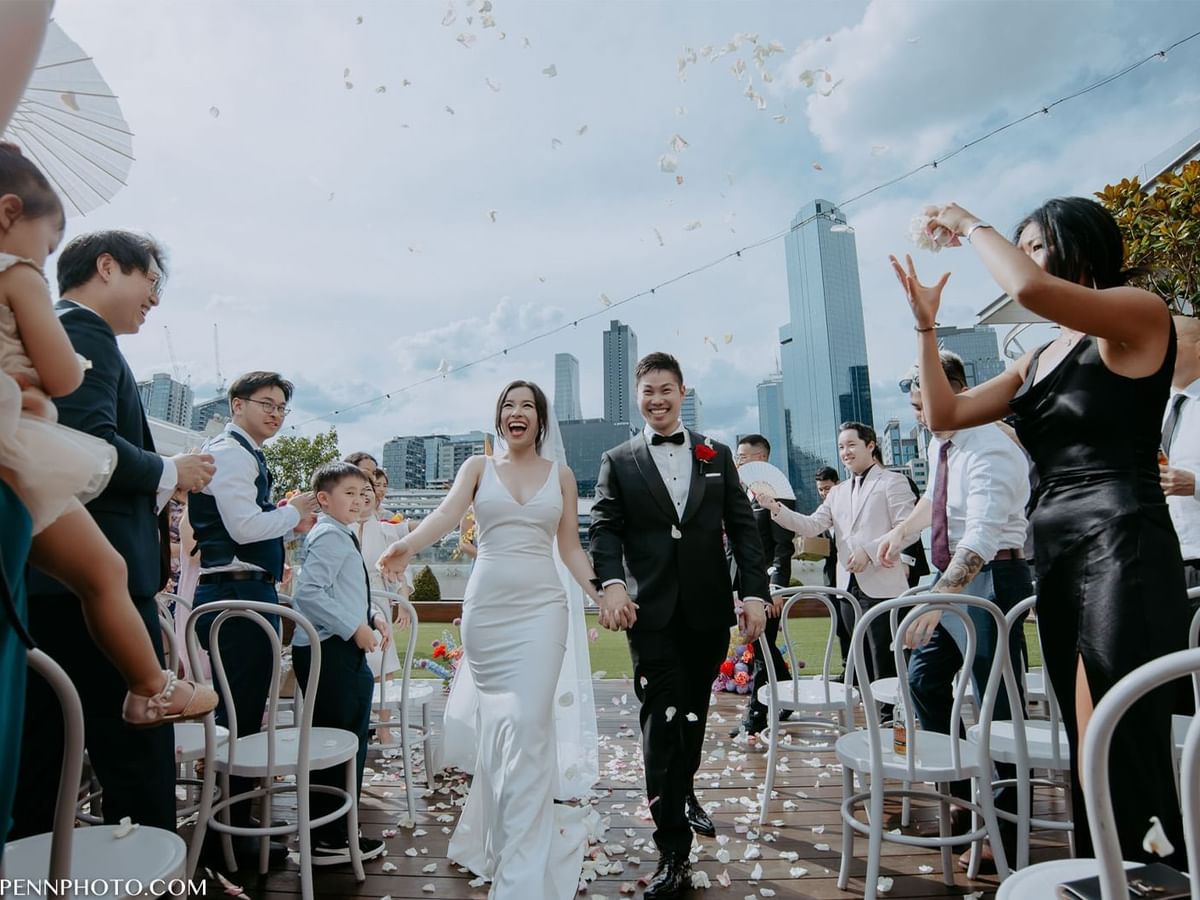 Wedding ceremony of Mai and Godwin with guests throwing petals at Crown Towers Perth