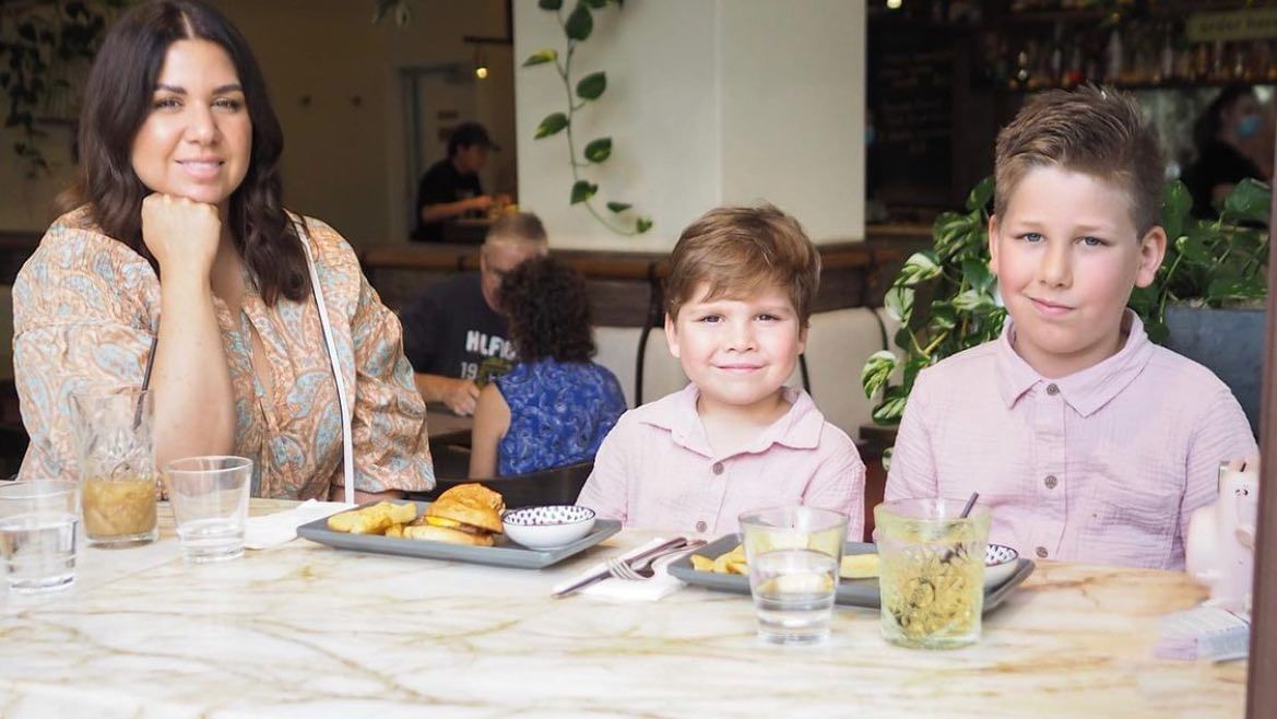 Mother and two boys enjoying a relaxing family meal at a marble-top table inside a casual restaurant at The Sebel Brisbane