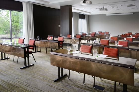 large conference room with long tables and red chairs