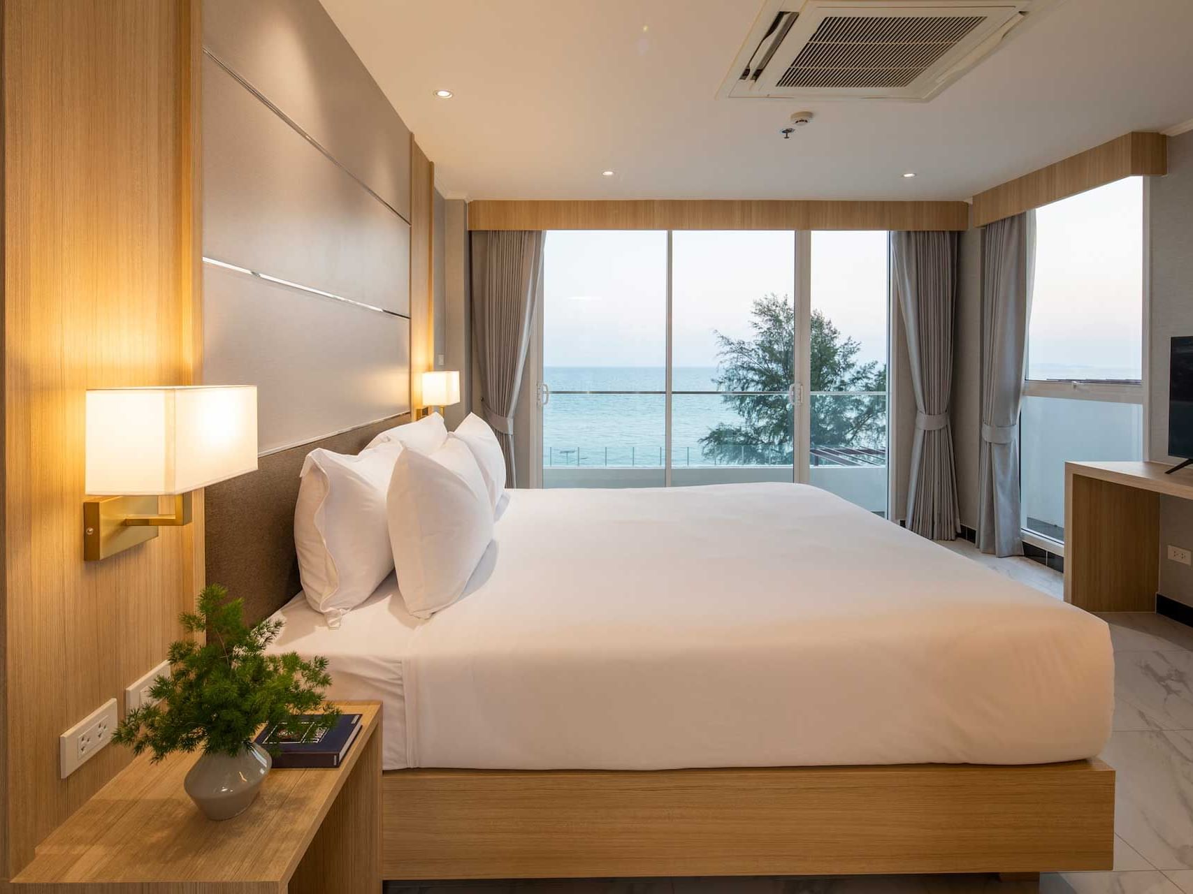 Large bed with wall lamps & TV in Suite Seaview at Eastin Resort Rayong