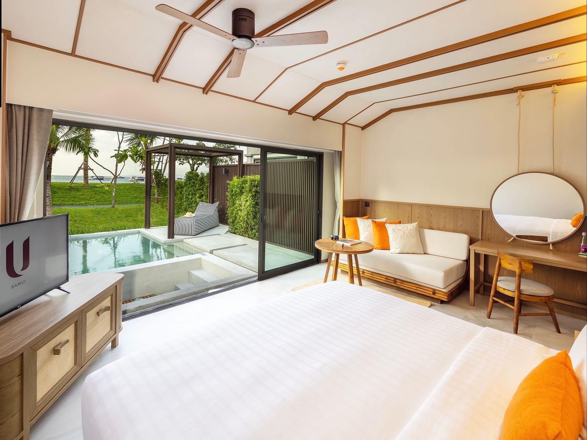 Bed with a TV in Beachfront Pool Villa at U Hotels and Resorts